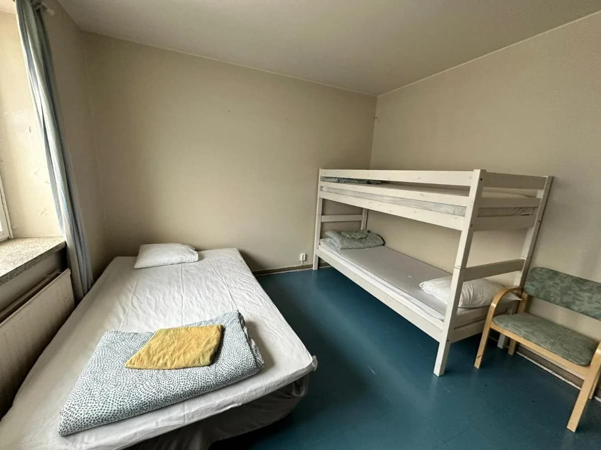 Kolmen hengen huone yhdellä erillisellä vuoteella ja kahdella kerrossängyllä